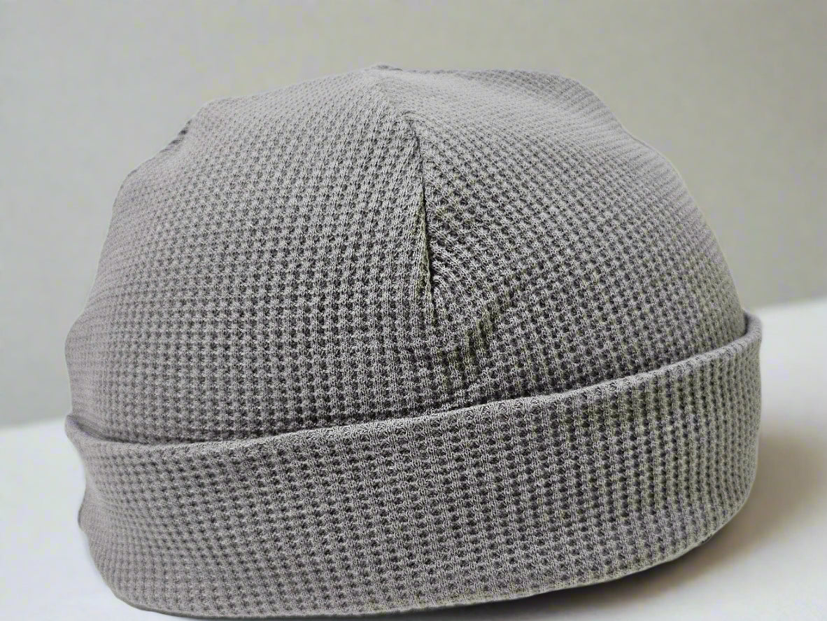 Gray knit beanie on a mannequin head against a white background