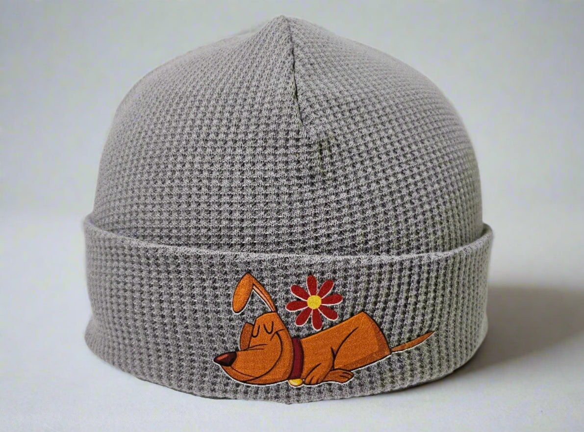 Gray knit beanie with a cartoon dog and flower design on a mannequin head against a white background
